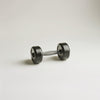 Single black metal dumbbell with rounded weights and a textured grip handle on a white surface.